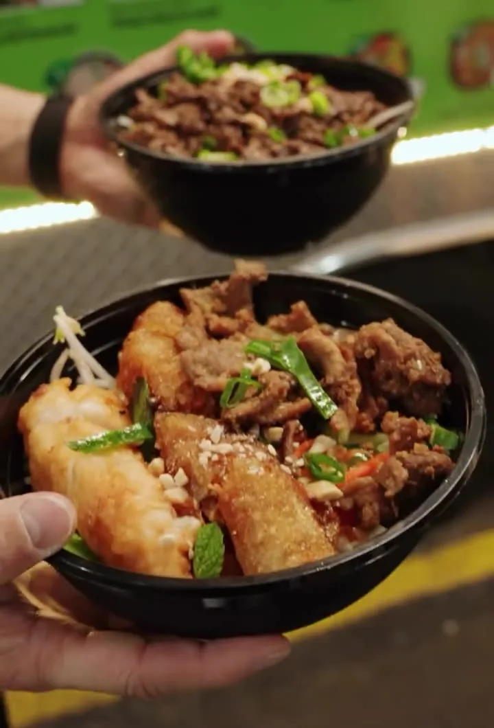 Two of our catering bowls held up at the truck: grilled beef with spring rolls, sugarcane prawn and spring onion