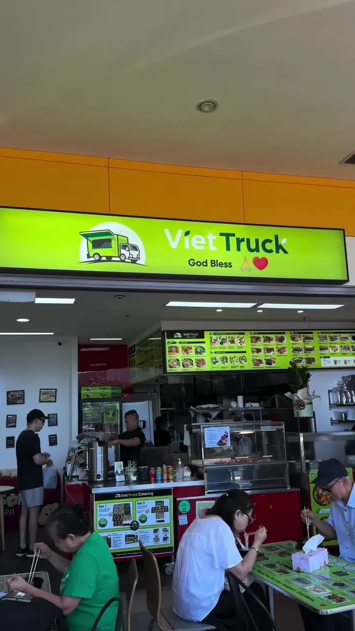 Our shop in Fairfield West Plaza under the lime-green VietTruck sign, with people eating at the tables