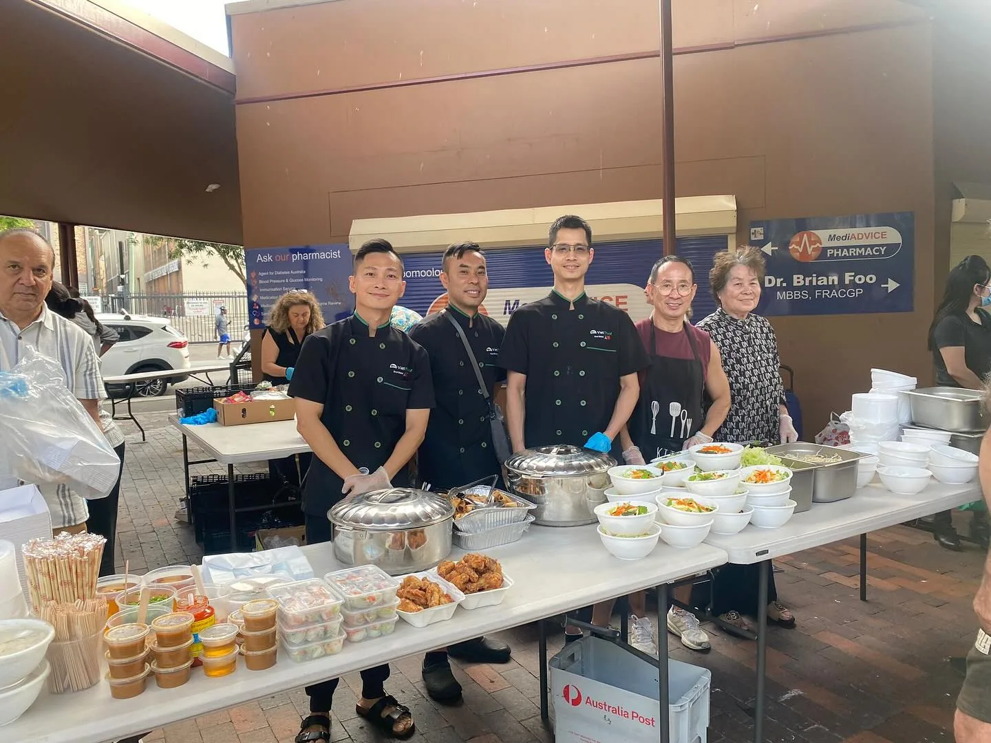 Our team behind a long table of food, serving a free community lunch